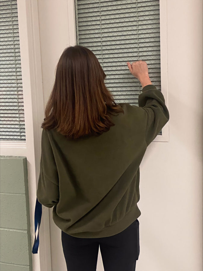 A student knocks on a classroom door due to the new rule to keep the doors locked at the beginning of each period.