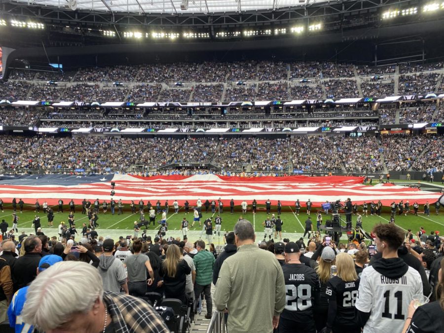 The crowd of fans stands for the national anthem at a Las Vegas Raiders game.