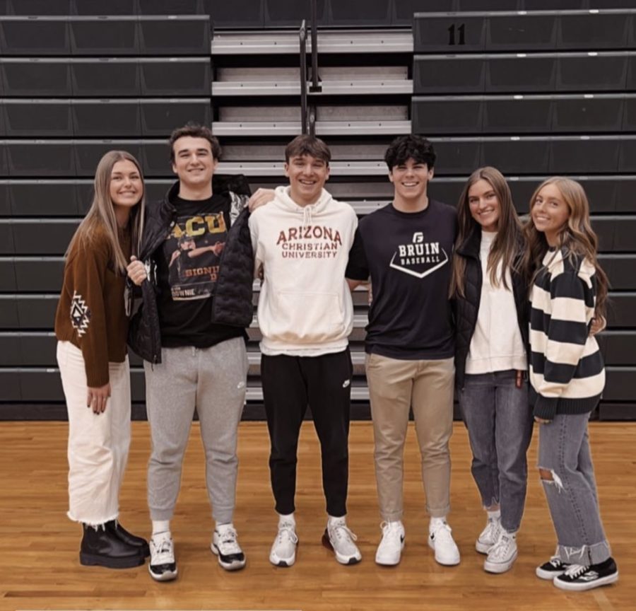 Students Madi Hauskins, Noah Skeesuck, Avery Charles and Avery Hassman support Senior baseball players Devon Downie and Grant Baskin at their signing day.