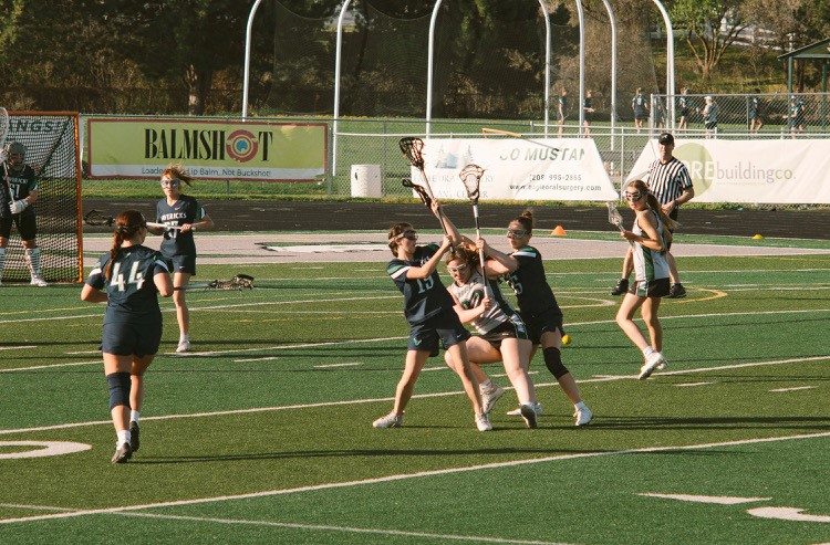 The Eagle High girls’ lacrosse team battled courageously for the ball in a game last year. Fall Ball has begun for the school year and the team conditions daily to get in shape for the season. 