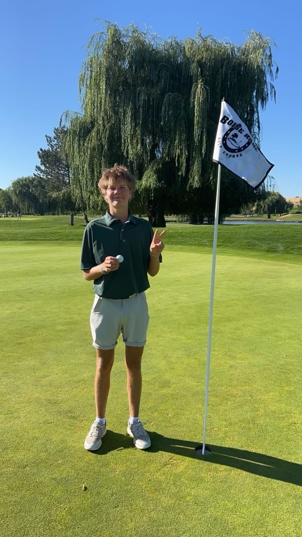 Member+of+the+Eagle+High+golf+team%2C+senior+Zach+Shipp+stands+next+to+a+pin+after+getting+a+hole+in+one+while+playing+at+Boise+Ranch+Golf+Course.++The+team+is+working+hard+this+season.
