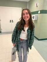 Sophomore Josie Roy poses in her comfy fall outfit. Roy is wearing a trendy flannel paired with a white top and straight-leg jeans. 