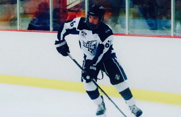 Member of the Eagle High hockey team and sophomore Enzo Stehrenberger slides on the ice in a game. He looks for the puck in anticipation. 