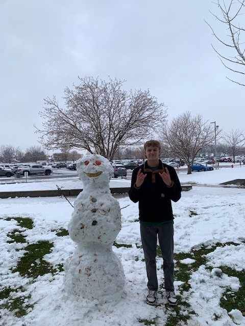 Junior Grant Cardwell poses in front of his snowman. Building a snowman is another fun Christmas activity.