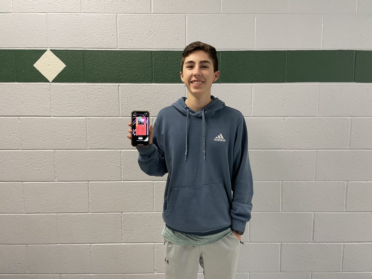Sophomore Graham Patterson stands in the lower east hall of Eagle High. The screen of his phone shows what his preference in music was in the last 12 months. His music taste changes throughout the year, and Spotify Wrapped can be a fun way to reflect on the year. 