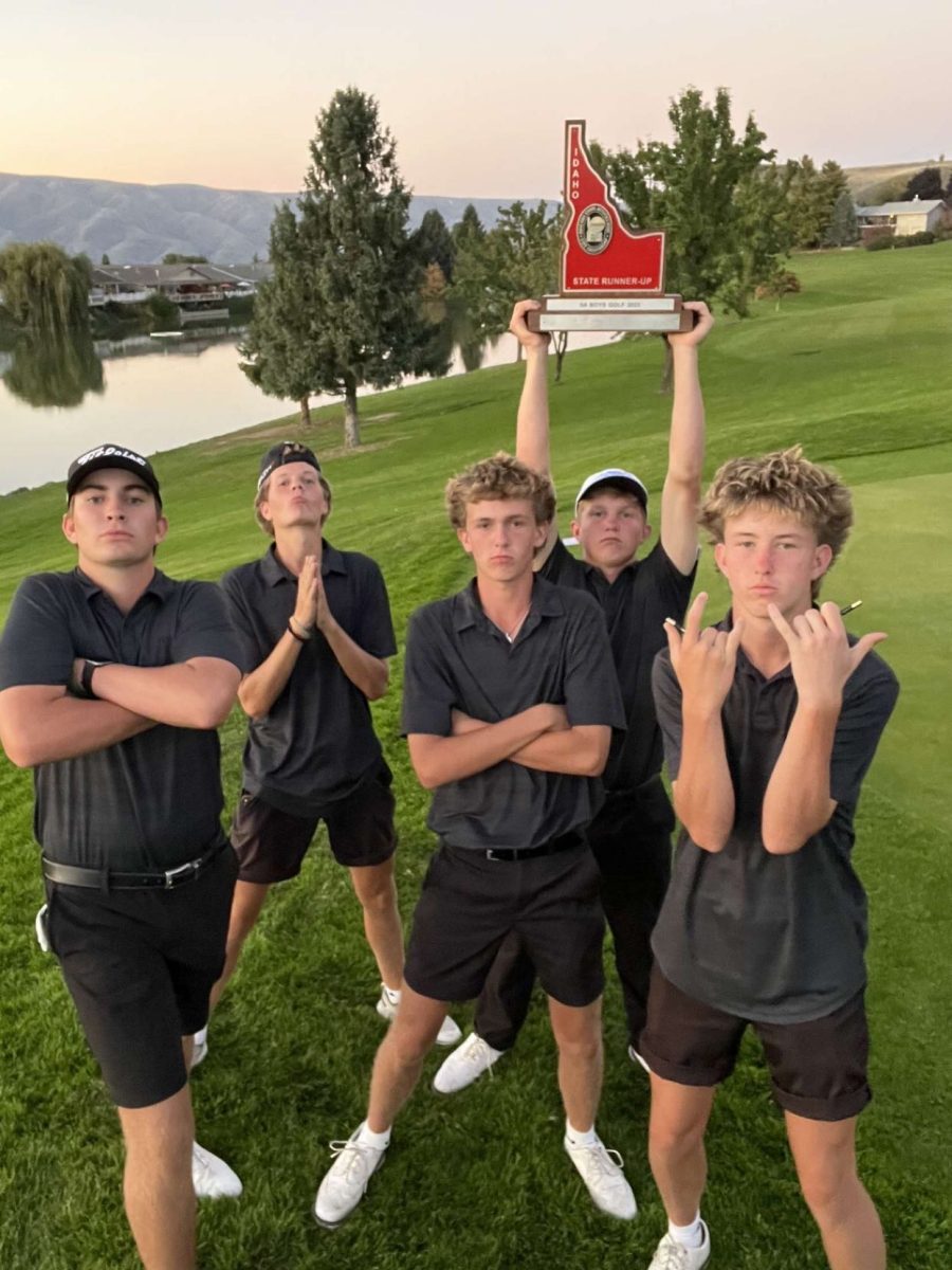 Senior Beckam MacGilvray hoists the second-place trophy over his head. The golf team poses for a photo on the golf course as their season comes to an end. 