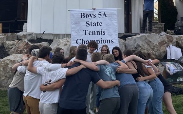 The Eagle High tennis team huddles together. Everyone on the team is united and celebrates success. 