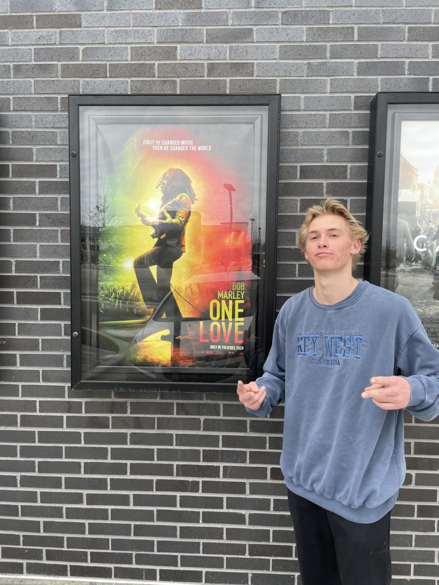Eagle High sophomore Casey Hulse poses in front of the Bob Marley movie poster. He loves Bob Marley and would recommend the movie.