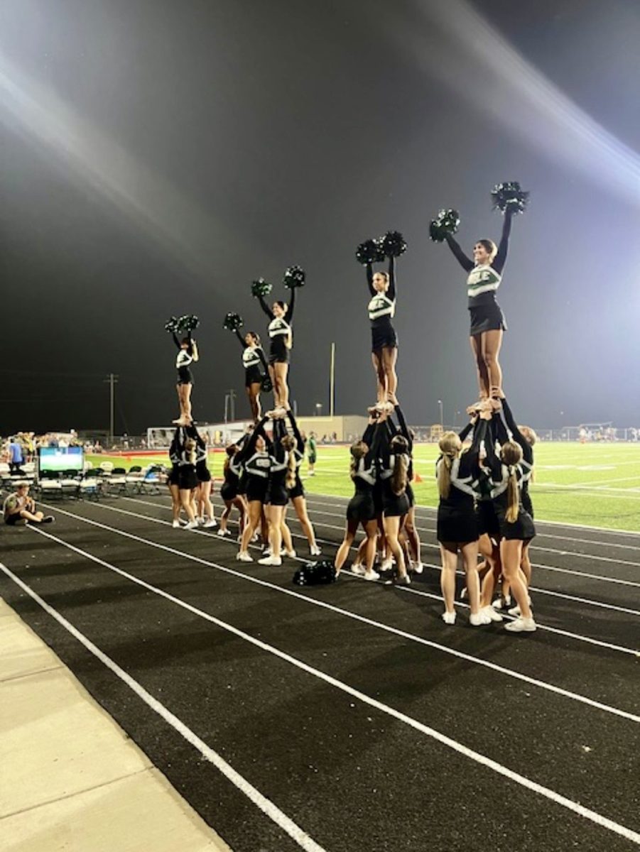 The Eagle High cheer team entertains the crowd during halftime at the first football game of the season. The cheer team is doing an extension stunt. 