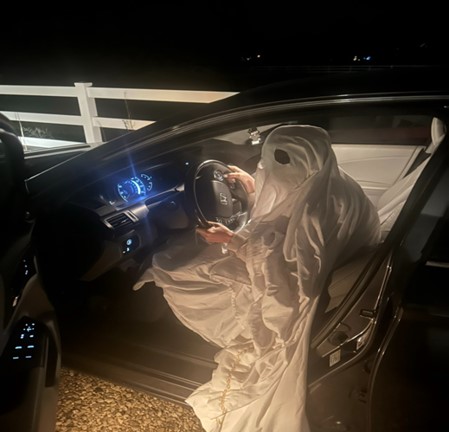 As the sun sets, junior Isabelle Bodily sits in her car, dressed as a ghost and ready for a night of thrilling ghost hunting. The nighttime vibe sets the perfect mood for an adventure filled with chills and thrills! 