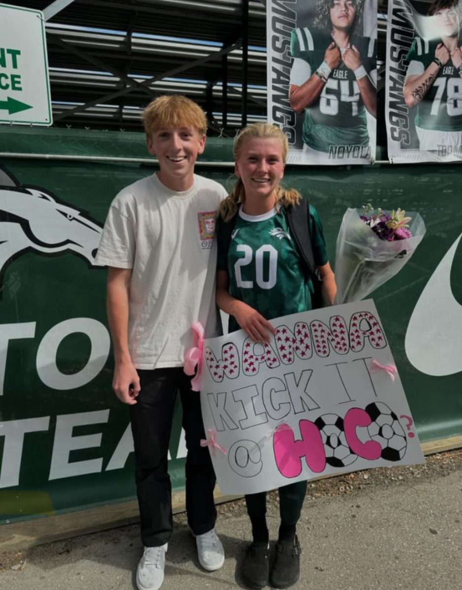 Sophomores Keegan Froke (left) and Lauren Lindley (right) smile with a pink soccer-themed  

Homecoming poster. Froke asks Lindley to go to the dance right after the Eagle High junior varsity girls’ soccer winning game.  