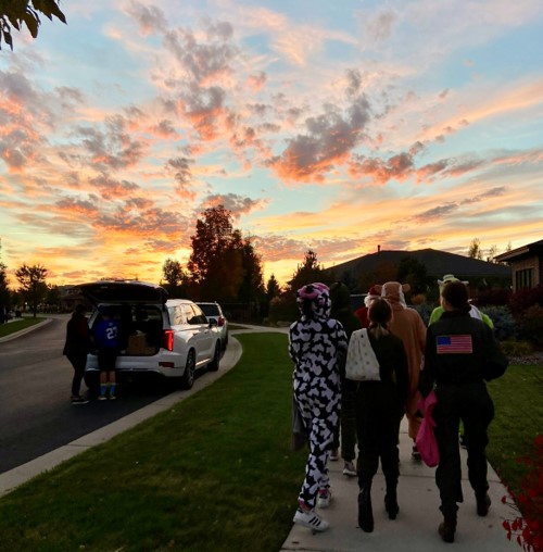 These kids are decked out in their costumes on Halloween day. They eagerly head out to collect some candy, and their enthusiasm for trick-or-treating is infectious.