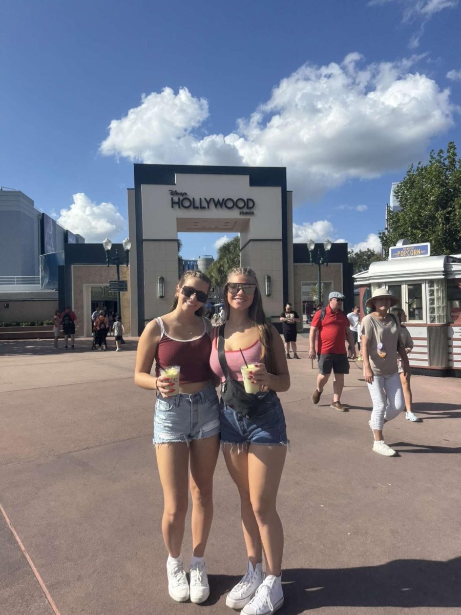 Juniors Ellie Erickson and Lauren Hitchcock attend Disney's Hollywood Studios in Florida. They stand in the sun preparing for the fun they are going to have in this fun travel destination.  