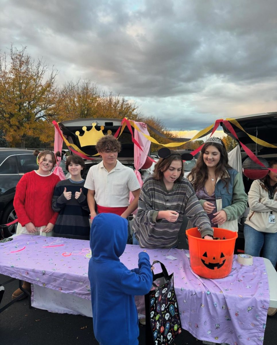 Junior Elisia Henry, junior Oliver Rhoades, senior Cole McAdams, senior Jess Parks and senior Peyton Studer hand out candy at the Eagle High trunk or treat event on Oct. 28. Many children came to the trunk or treat and enjoyed all the candy and fun. 