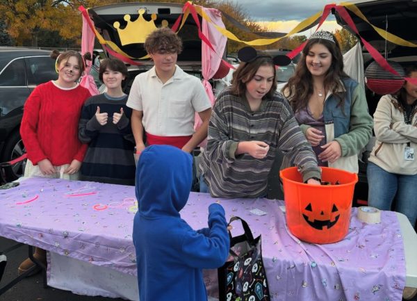 Junior Elisia Henry, junior Oliver Rhoades, senior Cole McAdams, senior Jess Parks and senior Peyton Studer hand out candy at the Eagle High trunk or treat event on Oct. 28. Many children came to the trunk or treat and enjoyed all the candy and fun. 