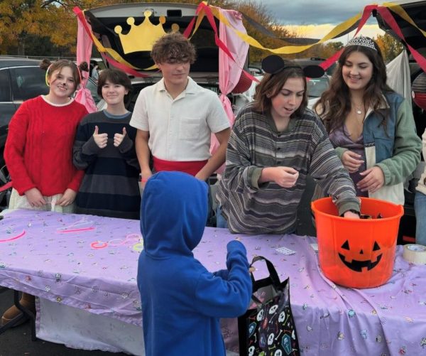 Junior Elisia Henry, junior Oliver Rhoades, senior Cole McAdams, senior Jess Parks and senior Peyton Studer hand out candy at the Eagle High trunk or treat event on Oct. 28. Many children came to the trunk or treat and enjoyed all the candy and fun. 