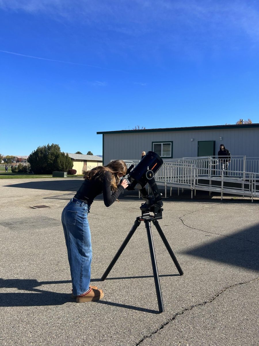 Junior Rebecca Gabriel uses a telescope to look at the stars, planets and other space related things such as the Europa Mission. This mission is aimed to investigate Jupiter and search for signs of extraterrestrial life. 