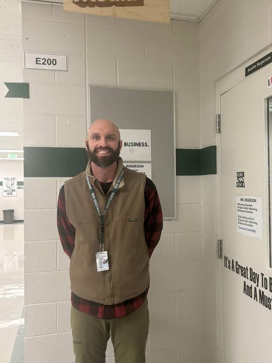 Business essentials teacher and BPA advisor Austin Rogerson shows his knowledge for the business word with signs outside his classroom. Without him, the BPA club would not run smoothly. 