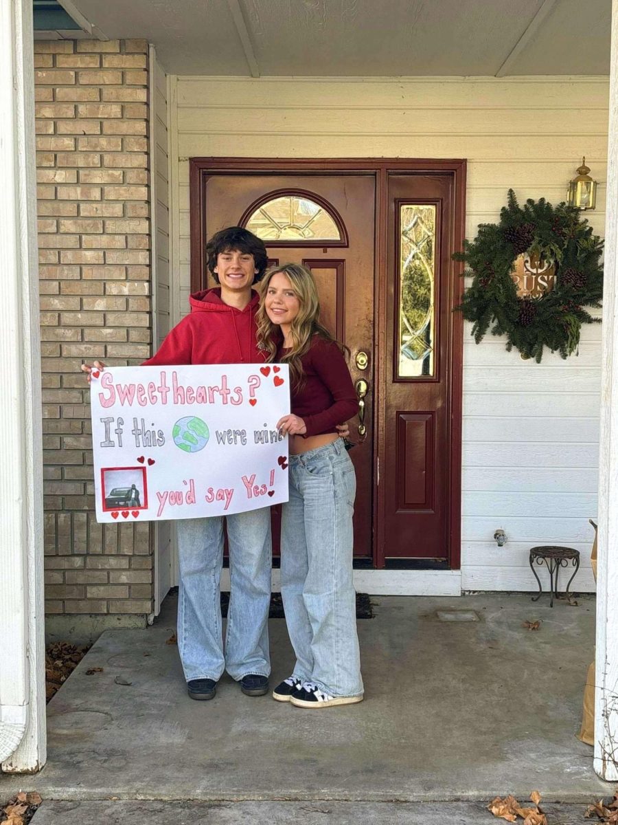 Sophomore Maddie Giorgetti and sophomore Keaton Rust pose for a photo after she asked him to Sweethearts. Giorgetti's poster is based on the song “Luther” by Kendrick Lamar, one of Rust’s favorite songs. This year, many girls at Eagle High made creative posters like this to ask boys to the dance. 