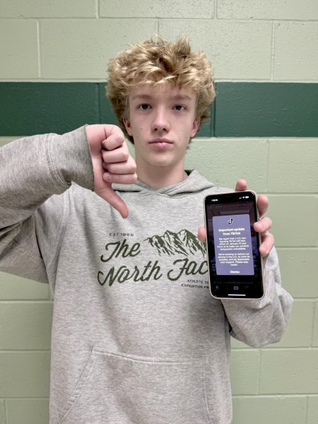 Sophomore Cole Jones holds up a photo of the notification everyone got when TikTok was temporarily banned in the United States. Many agreed with the ban and said that it would benefit the country, but many disagreed. 