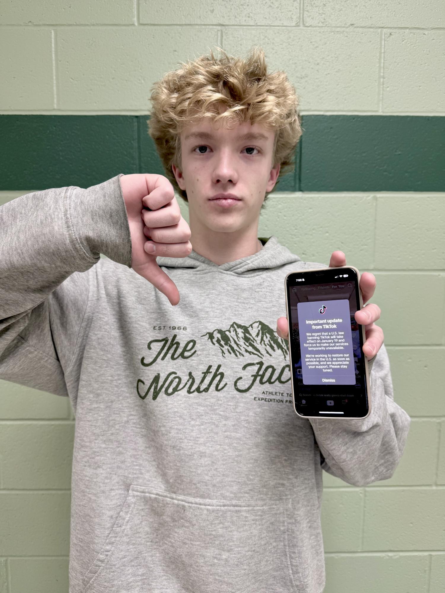 Sophomore Cole Jones holds up a photo of the notification everyone got when TikTok was temporarily banned in the United States. Some agreed with the ban and said that it would benefit the country, but many disagreed. 