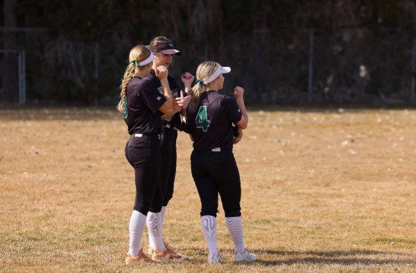 Senior Alyson Viera, junior London Sanfilipo-Cook and sophomore Reese Norcutt gather on the outfield to assess a play in a game against Ridgevue High. Outfield players that have a strong plan of action are critical to a successful game.