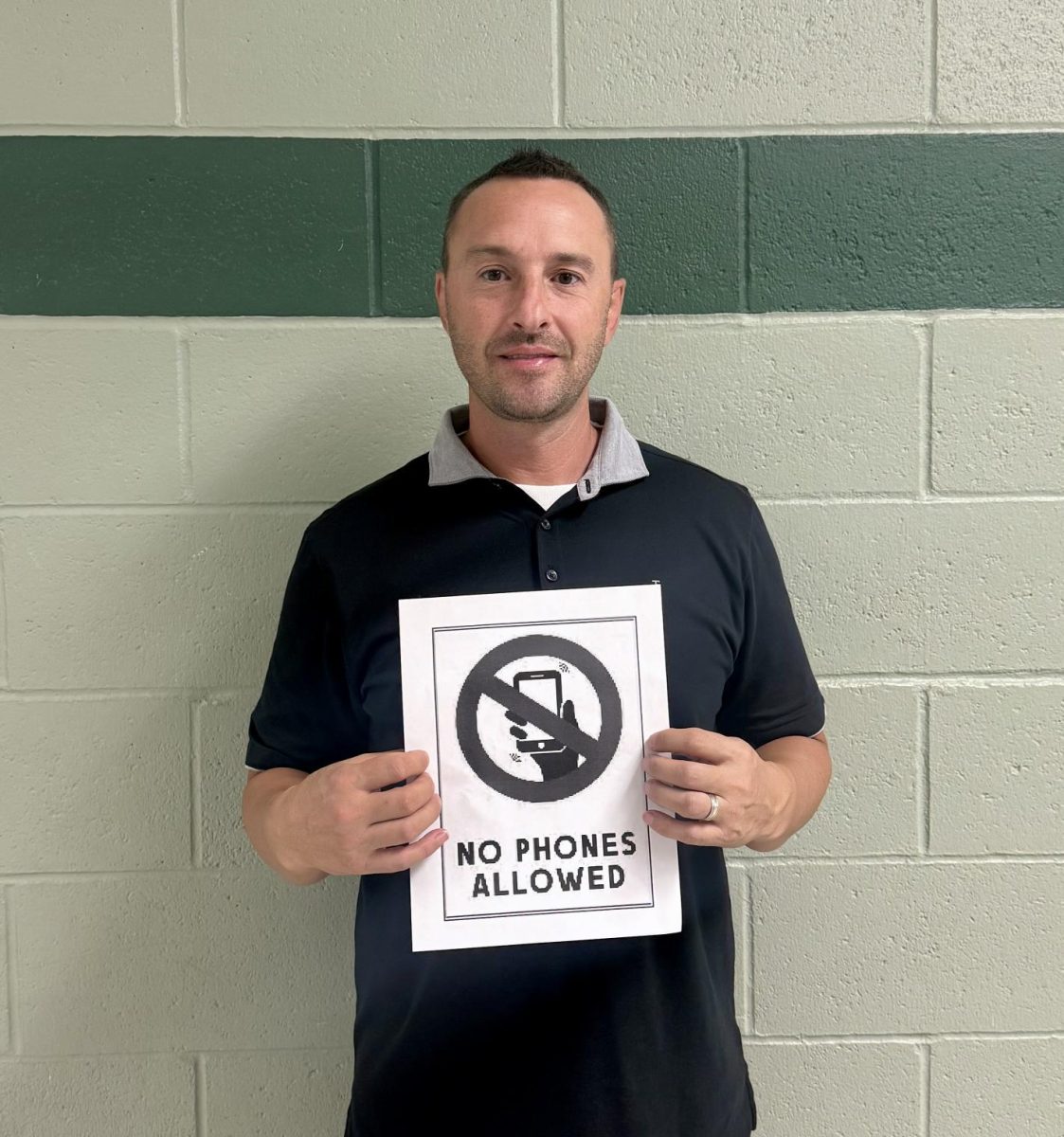 Activities director Tony Brulotte holds a sign that states no phones are allowed. In Texas, no phones are allowed on any public-school campus. This could set an example to lawmakers in Idaho to enforce this rule. 