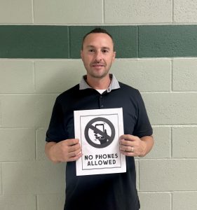 Activities director Tony Brulotte holds a sign that states no phones are allowed. In Texas, no phones are allowed on any public-school campus. This could set an example to lawmakers in Idaho to enforce this rule. 