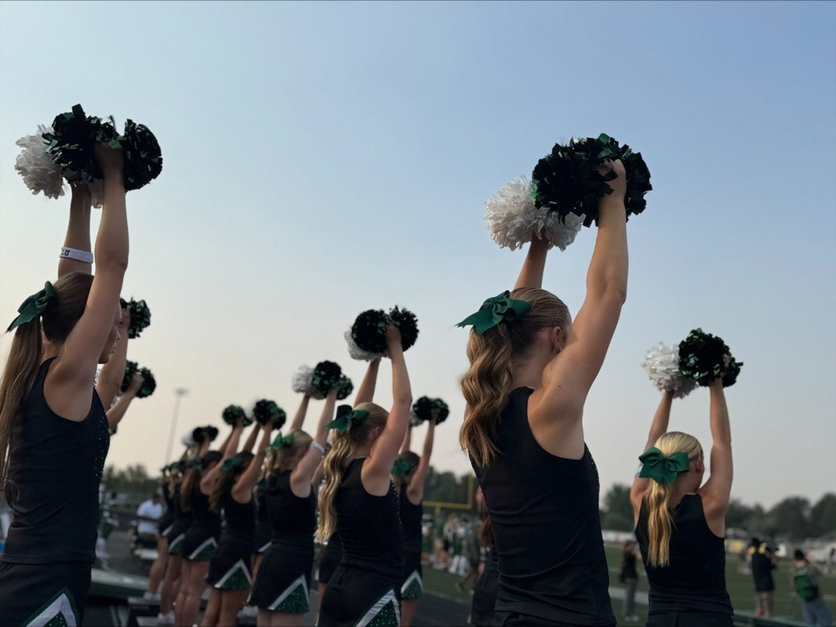 Eagle High Cheerleading faces their pom poms towards the sky as the football team faces their third quarter kickoff. 