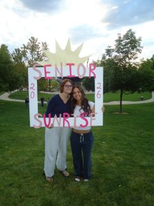 Seniors Mary Richardson and Alyssa Orchard pose behind a homemade frame during senior sunrise. They look forward to the new year kicked off by watching the sunrise together. 