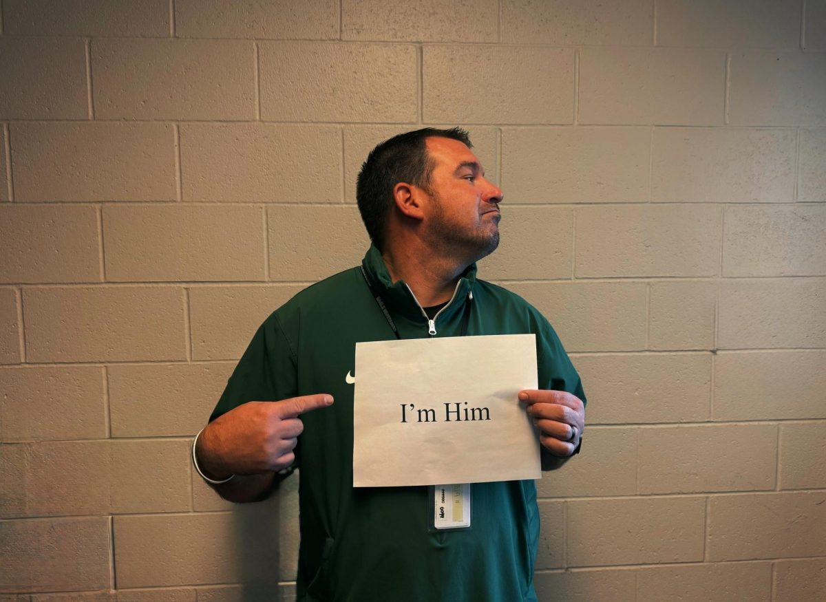 Teacher Zach Farnum holds up a paper that says, “I’m Him.” This is one of the many student lingo terms that Farnum hears from students every day. 