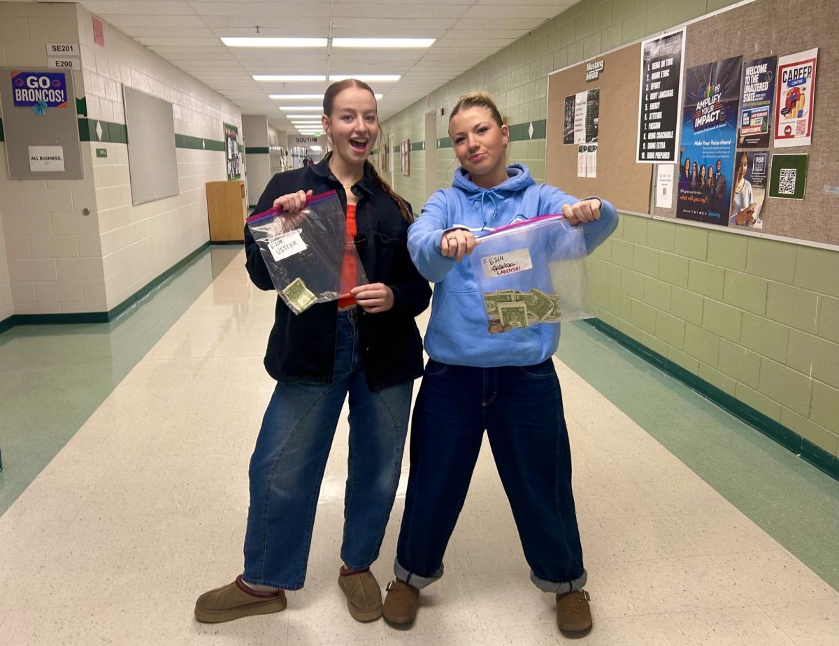 Sources of Strength members senior Audrey Baxter and junior Evelynne Whiting collect cash donations that will be counted. They count new and incoming donations so they can update donation goal posters throughout the school.