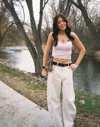 Junior Maecy Page poses in front of the Bosie River showing off her new spring outfit. After a cold winter of wearing sweaters, she’s excited to finally wear tank tops.  