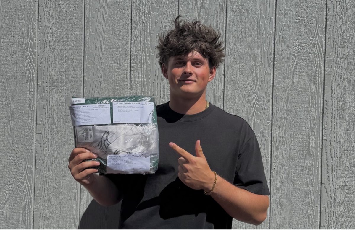 The Eagle High graduation ceremony will take place at the Idaho Central Credit Union Arena on May 19. Students will be decorated in their caps and gowns as well as chords to commemorate their accomplishments throughout their high school career. Senior Caleb Zawadzki holds up his cap and gown he will wear to graduation.