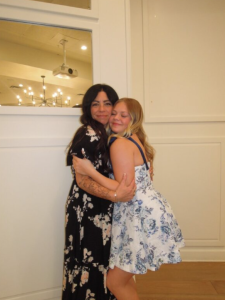 Senior and co-captain of Eagle High varsity cheer Adelie Cook poses with her four-year mentor, varsity cheer coach Anna Ordaz, at the end of year banquet to wrap up the season. Their endless memories and bonds will continue to stick with them.  